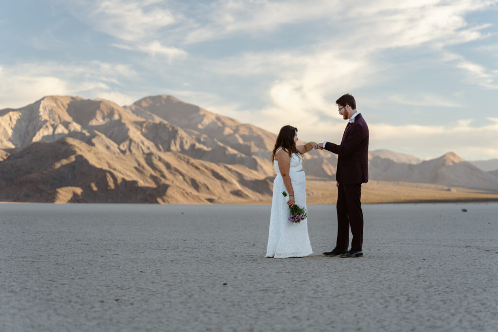 A couple fist bumps after eloping at the Racetrack in Death Valley 