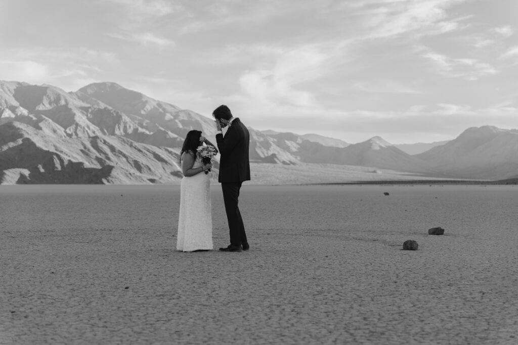 A couple are wiping away tears as they read vows to each other on a playa in Death Valley National Park