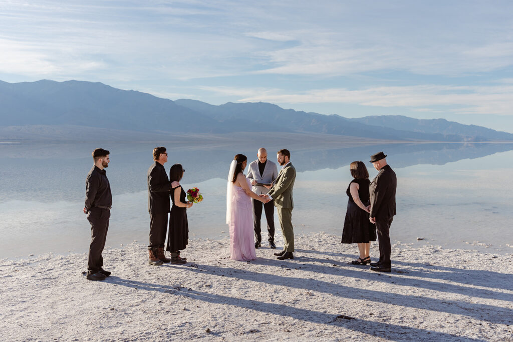 an elopement ceremony takes place on the edge of an ephemeral lake on the salt flats of Death Valley