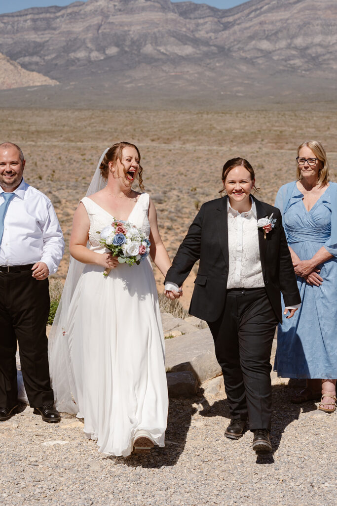 Two women walk away smiling immediately after becoming married