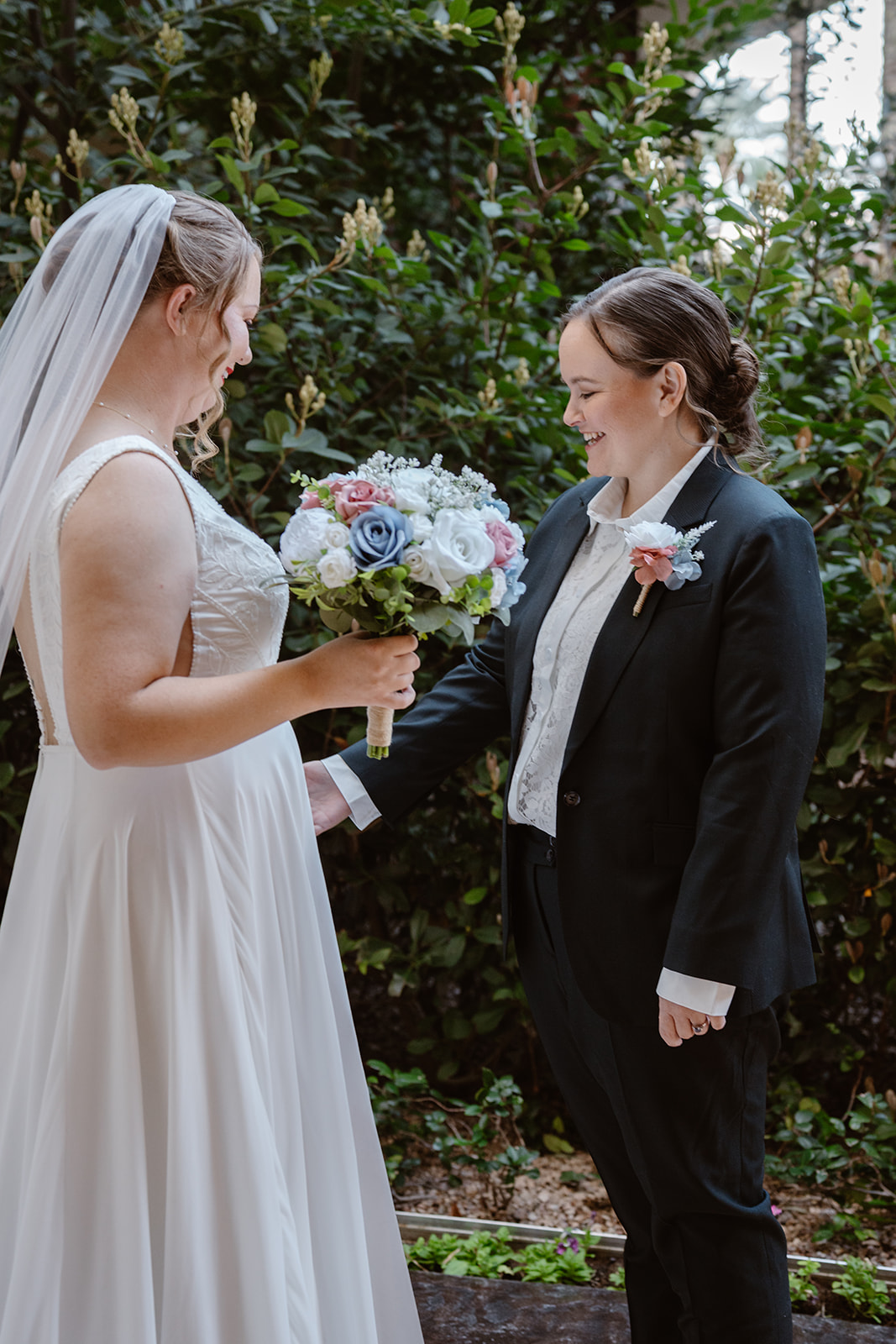 two brides admire each others outfits during their first look