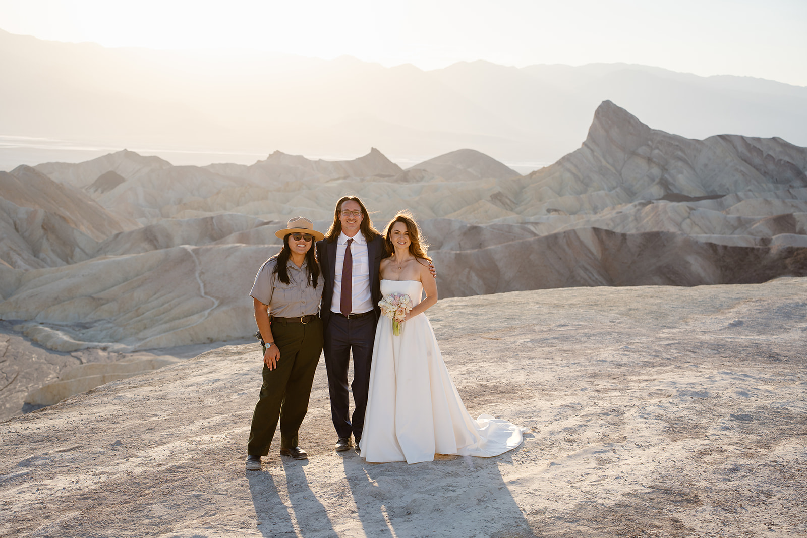 A park ranger stands next to a newly married couple in Death Valley National Park