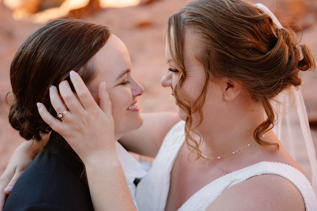 Two brides looking lovingly into each others eyes while smiling